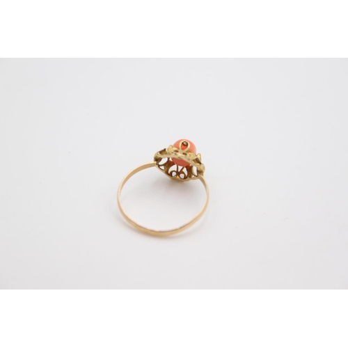 24 - An 18ct gold ornate solitaire coral bead ring, size K ½ - approx. gross weight 1.2 grams