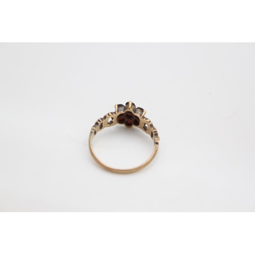 104 - A hallmarked London 9ct gold garnet flower ring, size N - approx. gross weight 2.2 grams