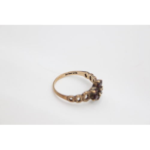 104 - A hallmarked London 9ct gold garnet flower ring, size N - approx. gross weight 2.2 grams