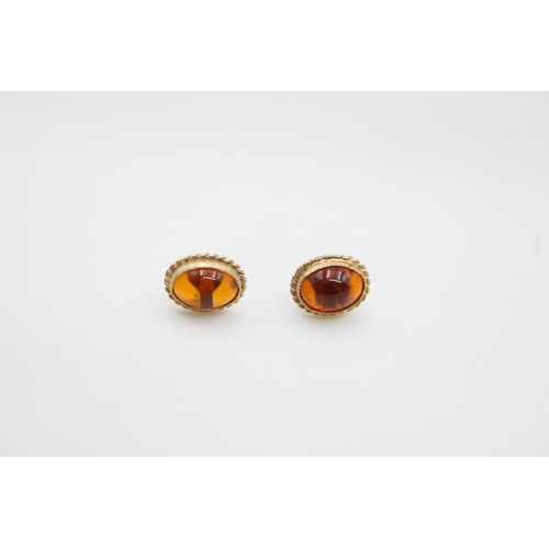 209 - A pair of 9ct gold amber stud earrings - approx. gross weight 0.9 grams