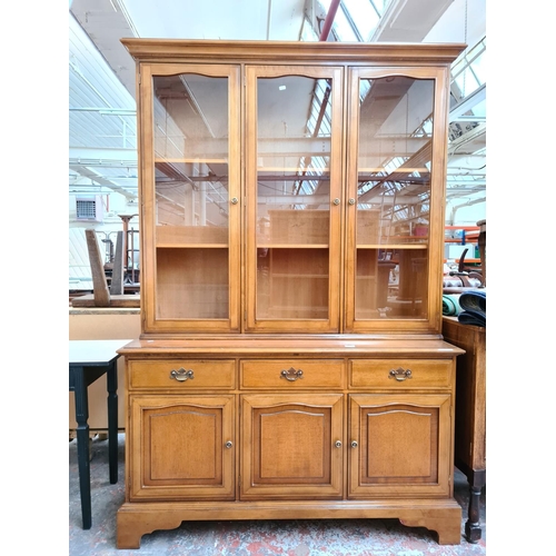 1096 - A late 20th century walnut display cabinet with three lower doors, three drawers, three glazed doors... 