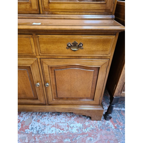 1096 - A late 20th century walnut display cabinet with three lower doors, three drawers, three glazed doors... 