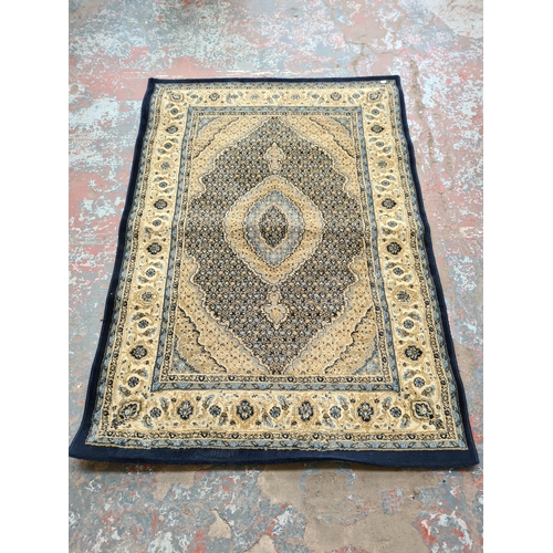 1099 - A late 20th century Turkish Prestige blue and ivory rug - approx. 120cm wide x 170cm long