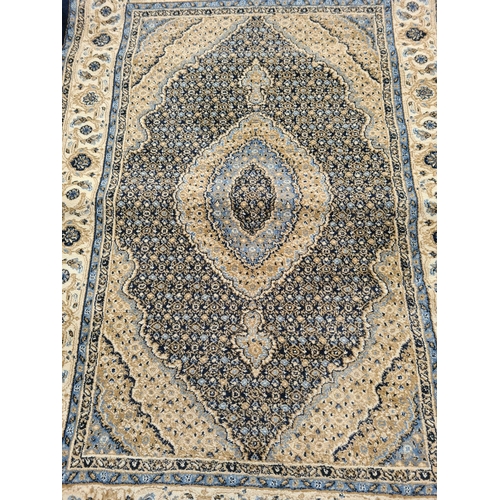 1099 - A late 20th century Turkish Prestige blue and ivory rug - approx. 120cm wide x 170cm long