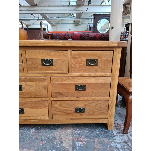 1103 - A modern light oak chest of seven drawers - approx. 85cm high x 130cm wide x 47cm deep