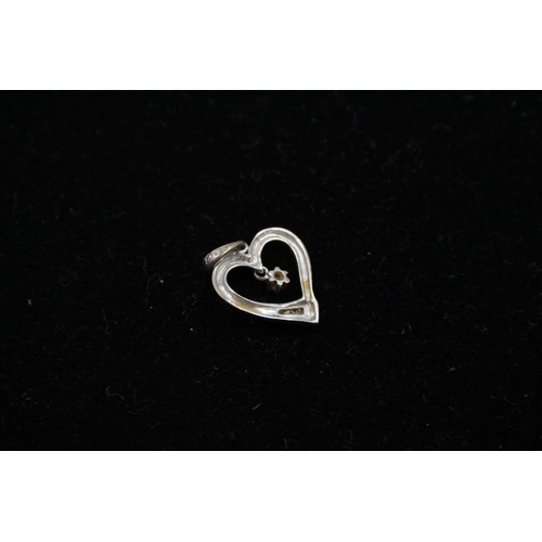 140 - Two 9ct white gold heart pendants to include one diamond - approx. gross weight 1.4 grams