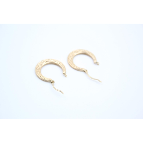 155 - A pair of 9ct gold Celtic design hoop earrings - approx. gross weight 1 gram