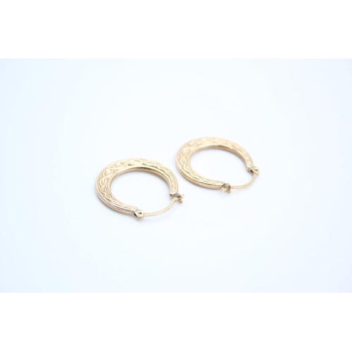 155 - A pair of 9ct gold Celtic design hoop earrings - approx. gross weight 1 gram