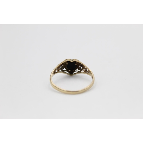 160 - A 9ct gold onyx heart ring with scrolling shoulders - approx. gross weight 1.2 grams