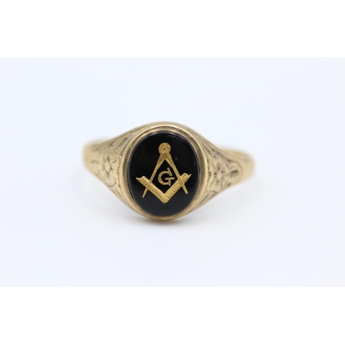 31 - A 9ct gold onyx masonic signet ring with floral design shoulders - approx. gross weight 3.5 grams