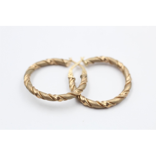 66 - A pair of 9ct gold twisted textured hoop earrings - approx. gross weight 2 grams