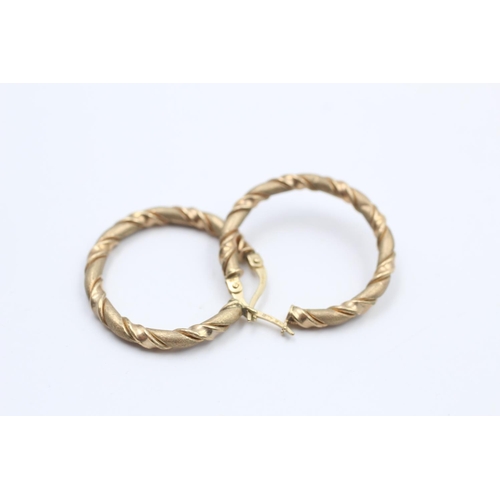 66 - A pair of 9ct gold twisted textured hoop earrings - approx. gross weight 2 grams