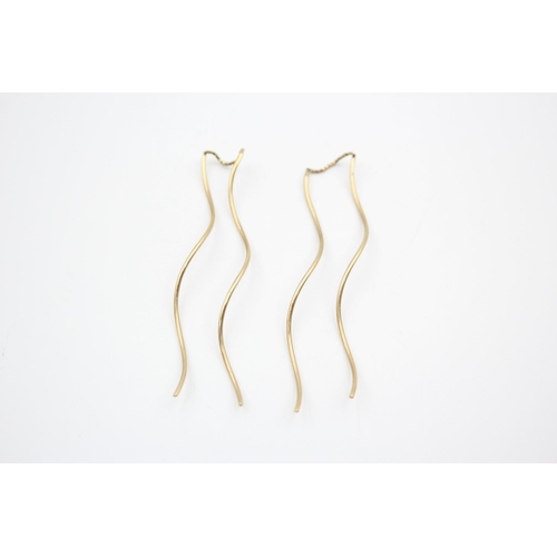 80 - A pair of 9ct gold thread through stylised earrings - approx. gross weight 1.9 grams