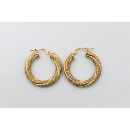 82 - A pair of 9ct gold twisted textured hoop earrings - approx. gross weight 1.8 grams