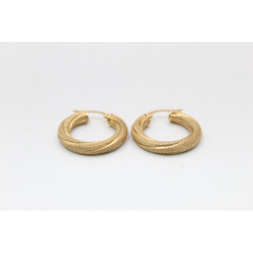 82 - A pair of 9ct gold twisted textured hoop earrings - approx. gross weight 1.8 grams