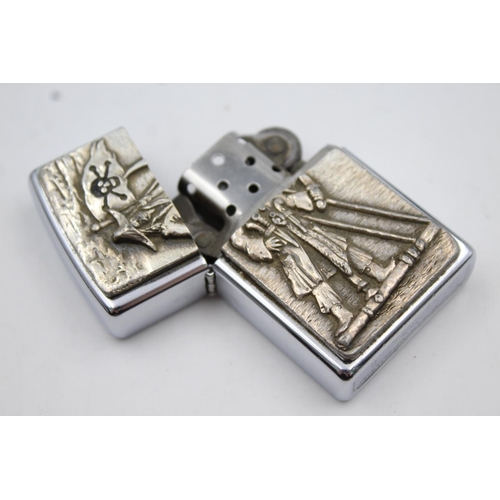 427 - Two Zippo cigarette lighters, one pirate themed and one Elvis Presley 50th Anniversary of U.S Army i... 