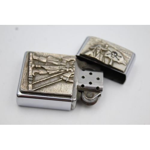 427 - Two Zippo cigarette lighters, one pirate themed and one Elvis Presley 50th Anniversary of U.S Army i... 