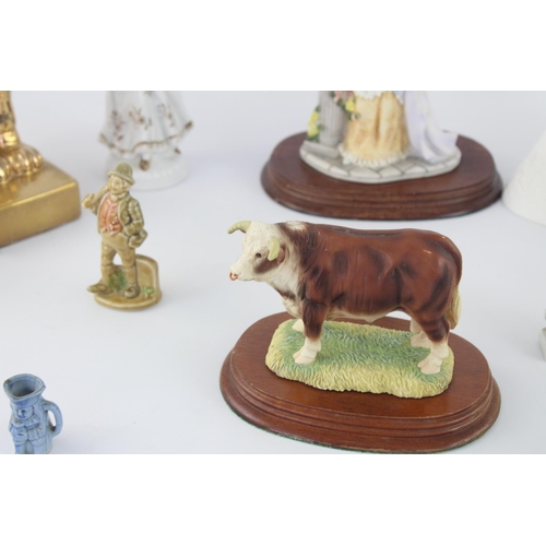 515 - A collection of assorted ceramic figurines to include Belleek, Wade Whimsies, Galos etc.