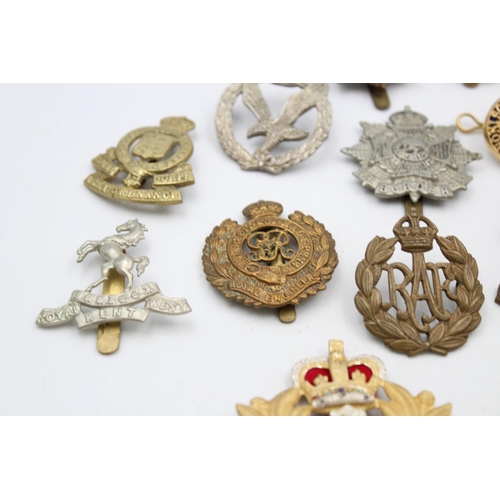 100 - Fifteen assorted vintage military cap badges to include Royal Armored Corps, South African Border et... 