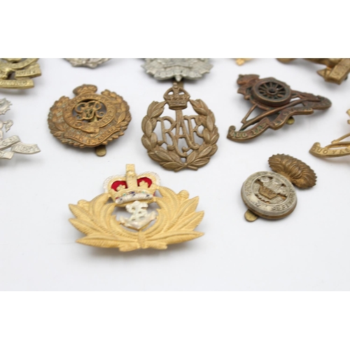 100 - Fifteen assorted vintage military cap badges to include Royal Armored Corps, South African Border et... 