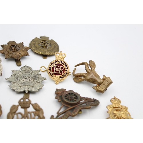 100 - Fifteen assorted vintage military cap badges to include Royal Armored Corps, South African Border et... 