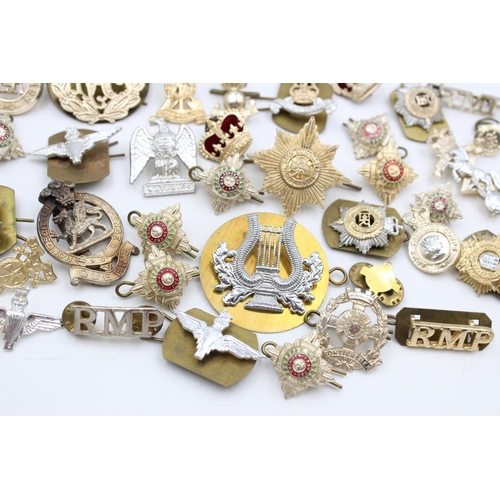 104 - A collection of assorted vintage military Staybrite badges to include cap, collar, shoulder etc.