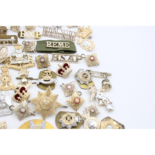 104 - A collection of assorted vintage military Staybrite badges to include cap, collar, shoulder etc.