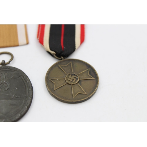 131 - Two WWII German medals, West Wall with packet and War Merit