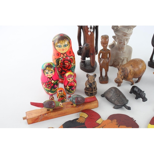 357 - A collection of assorted treenware to include, Russian dolls, ethnographic figurines, animal figurin... 