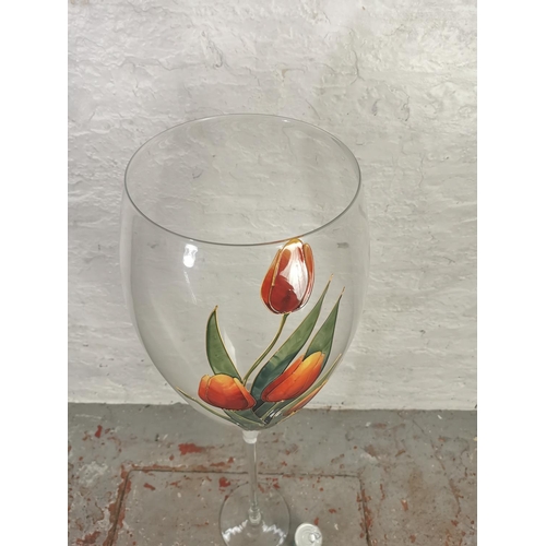 273 - A giant oversize wine glass with hand painted floral decoration signed S. S - approx. 120cm high