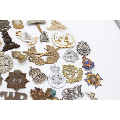 96 - A collection of assorted vintage badges to include two WWII A.R.P hallmarked sterling silver badges,... 