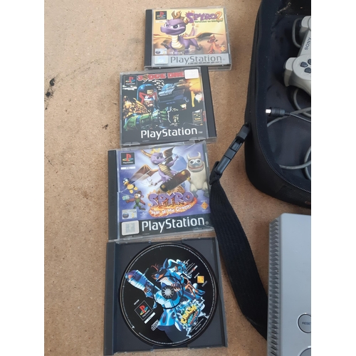 1145 - A cased Sony PlayStation SCPH-7502 with controller, power cable, RFU adaptor and seven games to incl... 