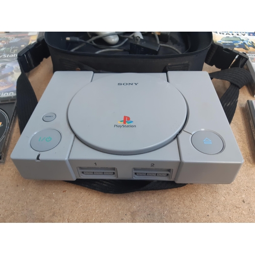 1145 - A cased Sony PlayStation SCPH-7502 with controller, power cable, RFU adaptor and seven games to incl... 