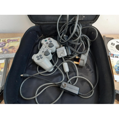 1145 - A cased Sony PlayStation SCPH-7502 with controller, power cable, RFU adaptor and seven games to incl... 