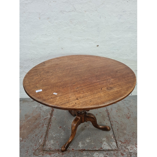 1011 - A George III oak circular tilt top tripod pedestal occasional table - approx. 74cm high x 90cm diame... 