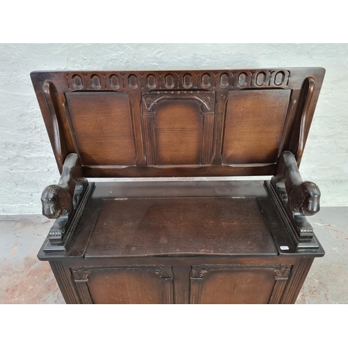 1014 - An oak monks bench with carved lion design arms and lower storage  - approx. 100cm high x 100cm wide... 