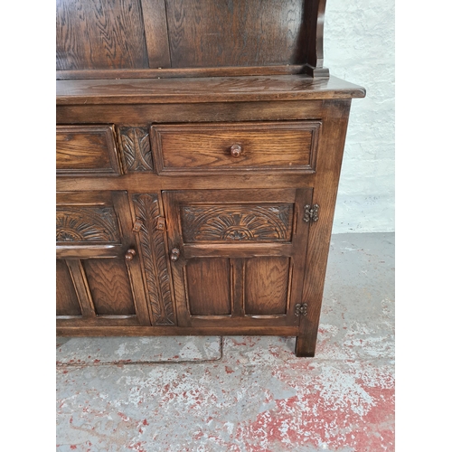 1015 - A Bevan Funnell Ltd. Reprodux oak dresser with carved floral decoration, two lower cupboard doors, t... 