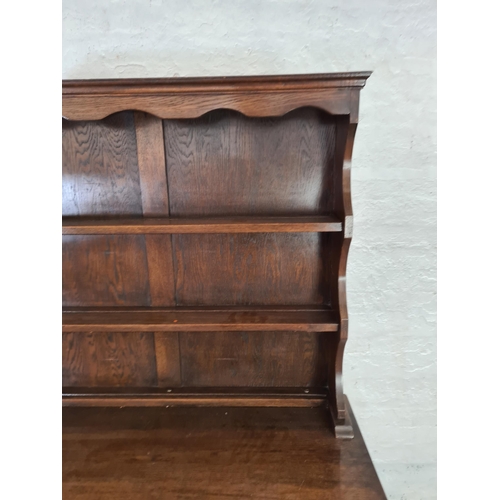 1015 - A Bevan Funnell Ltd. Reprodux oak dresser with carved floral decoration, two lower cupboard doors, t... 