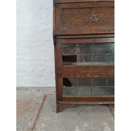 1017 - An early 20th century oak bureau bookcase with beaded design and leaded glass doors - approx. 137cm ... 