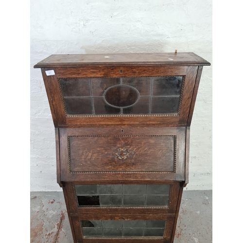 1017 - An early 20th century oak bureau bookcase with beaded design and leaded glass doors - approx. 137cm ... 