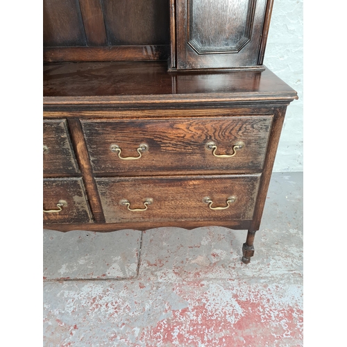 1018 - A Georgian style oak dresser with four lower drawers, two upper cupboard doors and plate rack - appr... 