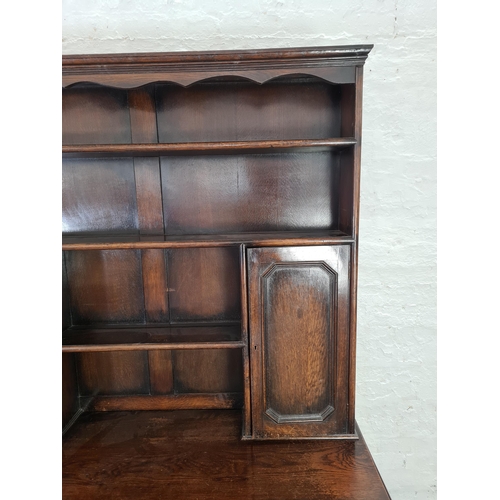 1018 - A Georgian style oak dresser with four lower drawers, two upper cupboard doors and plate rack - appr... 