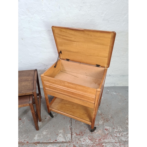 1032 - Two items, oak nest of two tables and mid 20th century oak and plywood two tier sewing table on cast... 