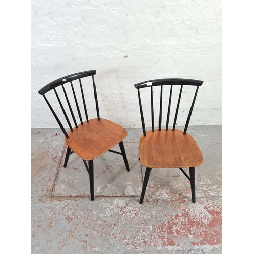 1042 - A pair of mid 20th century black painted elm spindle back dining chairs