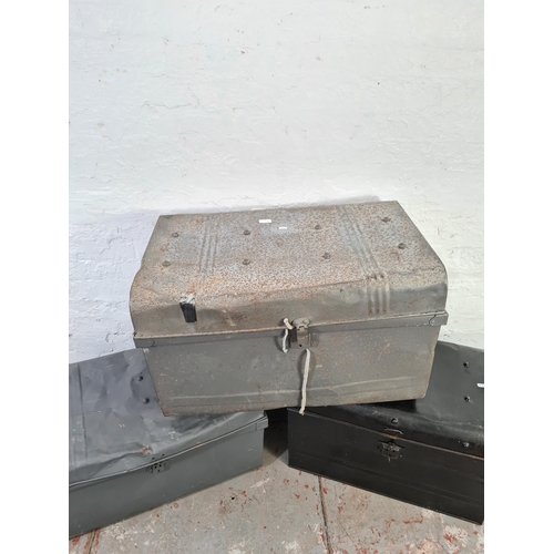 1051 - Three assorted black and grey painted metal travel trunks