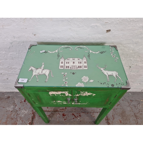 1055 - A vintage green painted two door cabinet with country scene printed top - approx. 74cm high x 51cm w... 