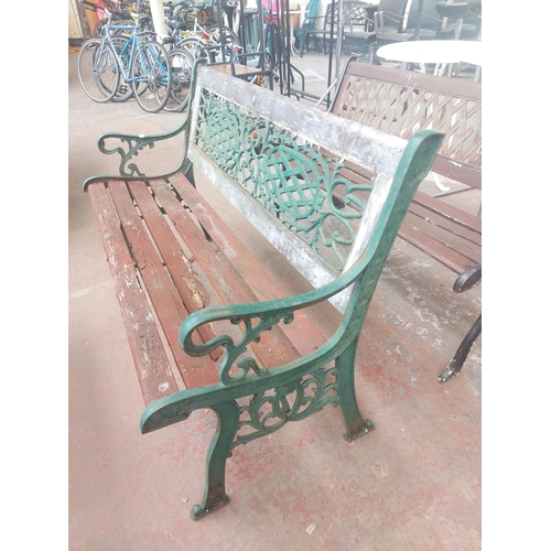 1240 - A wooden slatted three seater garden bench with ornate cast iron supports and back