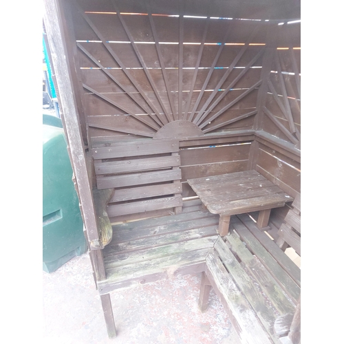 1250 - A wooden covered corner garden bench with central table - approx. 183cm high x 152cm wide