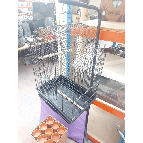 1261 - Three items, black metal bird cage, dog bed and fifty four terracotta plant pot holders