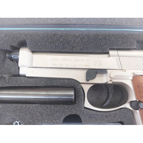 1284 - A cased Umarex Beretta model M92FS CO2 air pistol with wooden grip, silencer and gas cannisters